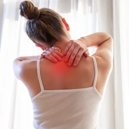 back of woman with hands on neck pain