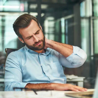 person working at desk with neck pain