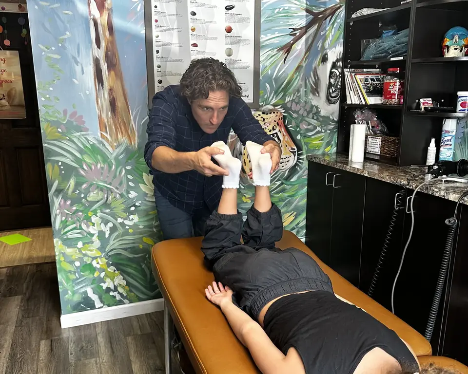 Dr. Zach Conner gently adjusting a child lying on the table in our jungle room